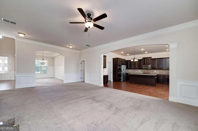 a kitchen with stainless steel appliances granite countertop a refrigerator a sink dishwasher a stove and oven with wooden floor