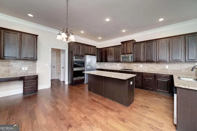 a kitchen with granite countertop cabinets a sink and appliances