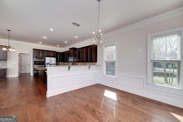 a view of a hallway with wooden floor and closet