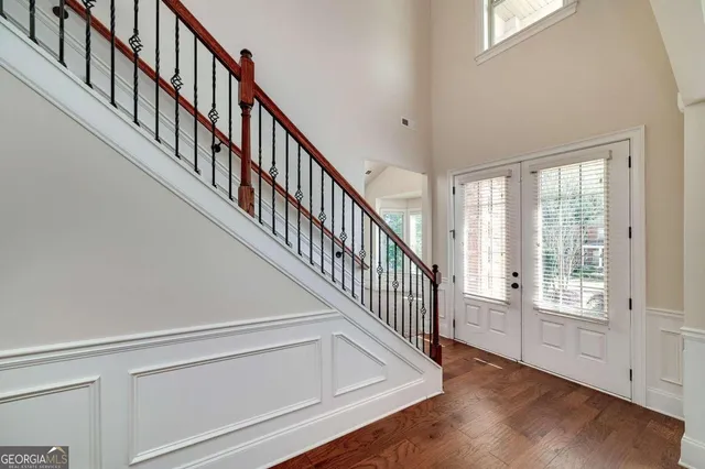 a view of a hallway with wooden floor and chandelier