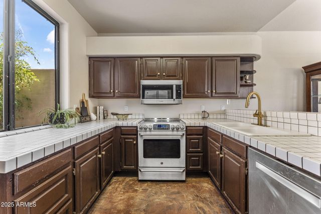 a kitchen with stainless steel appliances granite countertop a sink stove and microwave