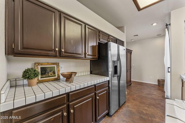 a kitchen with stainless steel appliances granite countertop a refrigerator a stove and a sink