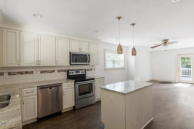 a kitchen with granite countertop white cabinets and white appliances