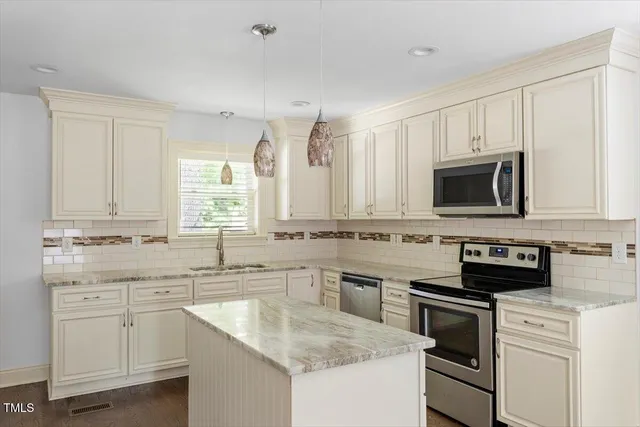 a kitchen with stainless steel appliances granite countertop a sink stove and microwave