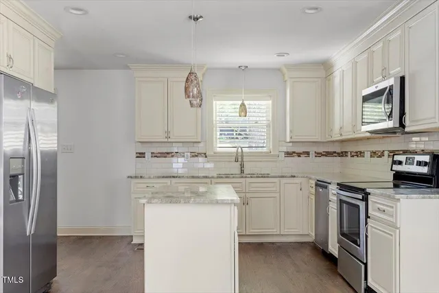 a kitchen with cabinets appliances a sink and a counter top space