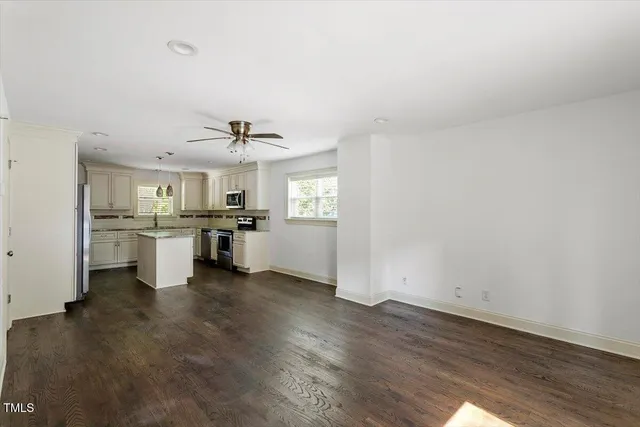 a view of a kitchen with a sink and dishwasher a refrigerator with wooden floor
