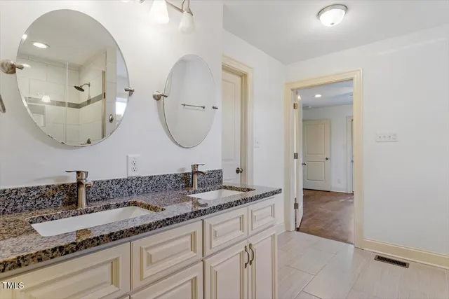 a bathroom with double vanity sinks and a mirror