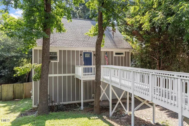 a view of a house with backyard and deck