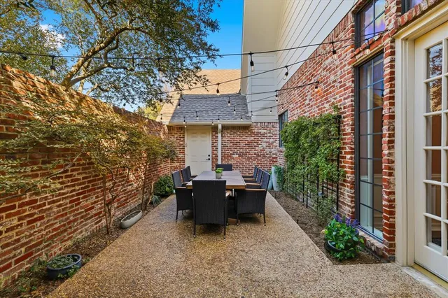 a view of a patio with couches and table and chairs and wooden fence