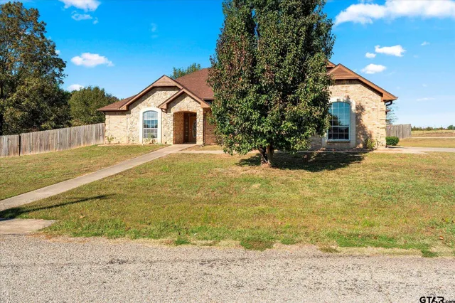 a view of a house with a yard and wooden fence