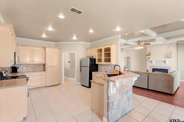 a kitchen with stainless steel appliances kitchen island granite countertop a stove a refrigerator a sink dishwasher and white cabinets with wooden floor