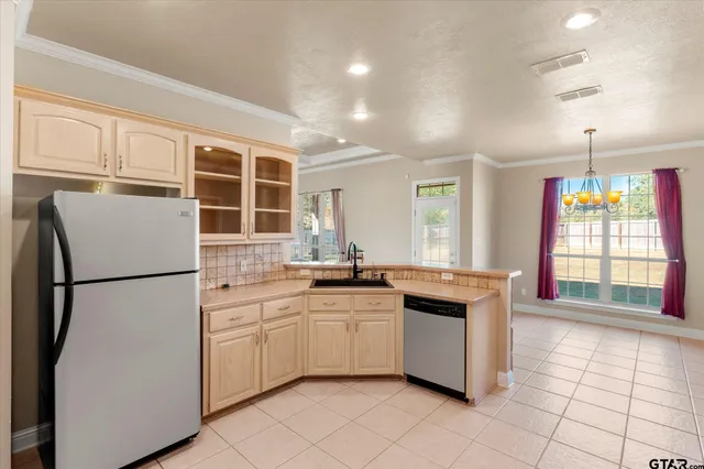 a kitchen with granite countertop appliances a sink and a refrigerator