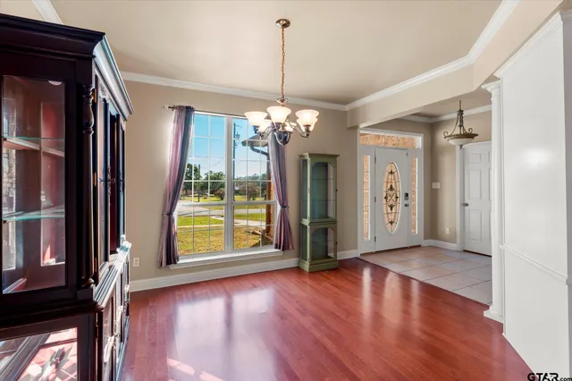 a view of a room with wooden floor fireplace and large windows