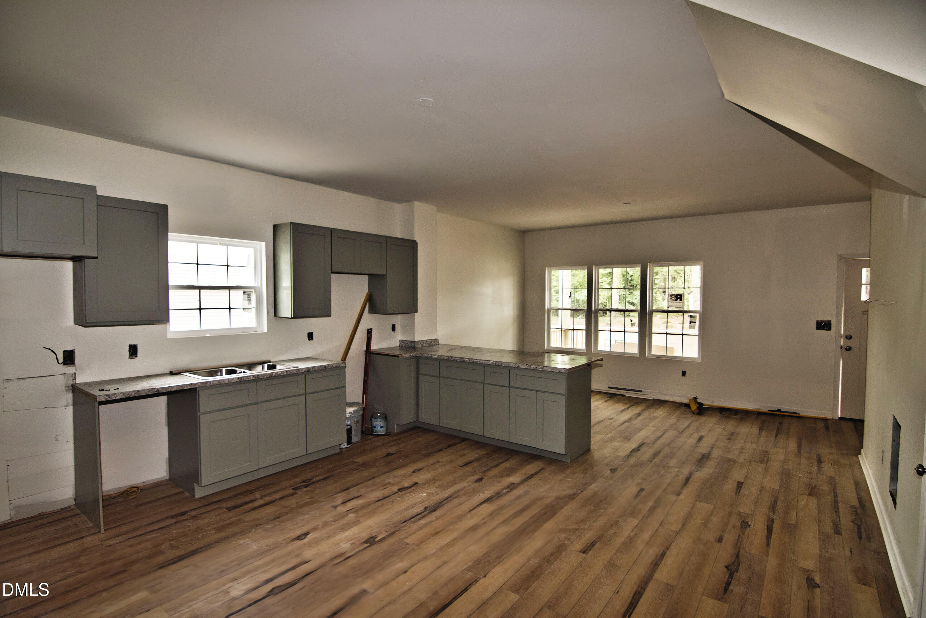1009 Ridge Rock Road Raleigh, NC 27610 - Photo 2 of 8 a large kitchen with a wooden floor and large windows