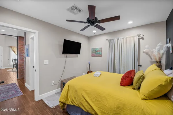 a bedroom with a bed and a flat tv screen on dresser