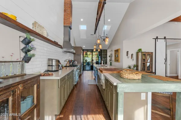 a kitchen with stainless steel appliances granite countertop a sink and a refrigerator