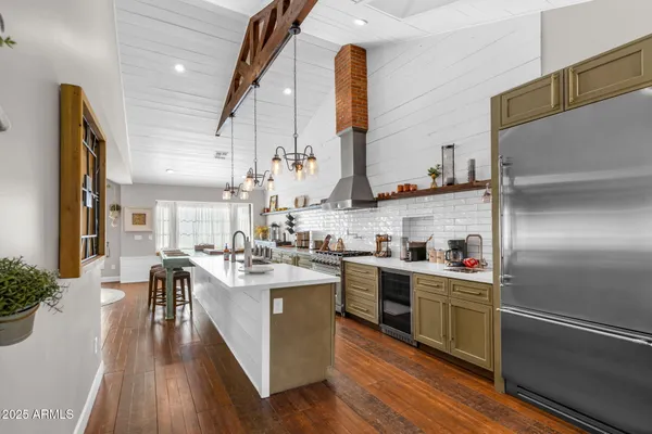 a kitchen with stainless steel appliances granite countertop a sink a stove and refrigerator