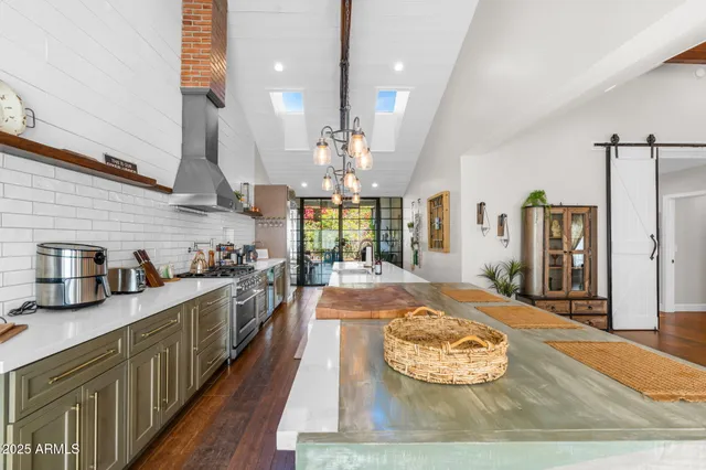 a kitchen with stainless steel appliances granite countertop a sink stove and refrigerator