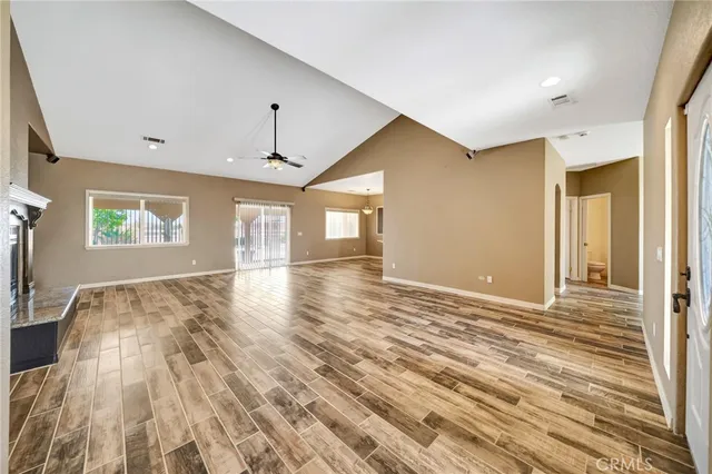 a large kitchen with stainless steel appliances granite countertop a sink dishwasher a stove and a refrigerator with wooden floor