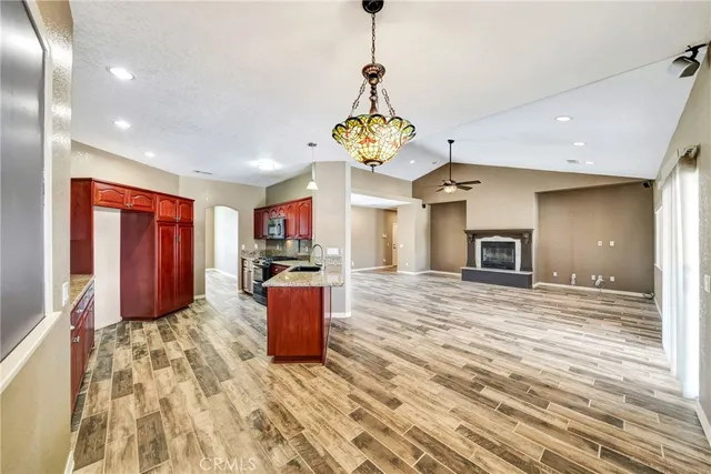 a open kitchen with stainless steel appliances kitchen island granite countertop a refrigerator and a sink