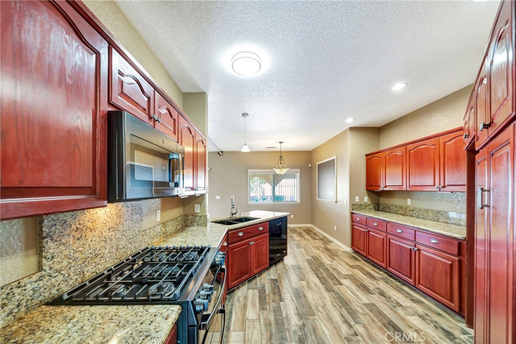 7315 West Ave A 8 Lancaster, CA 93536 - Photo 17 of 65 a kitchen with stainless steel appliances granite countertop a stove a sink and a microwave