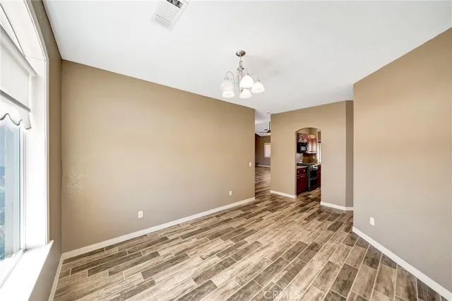 a view of an empty room with window and bathroom