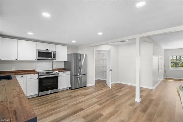 a kitchen with stainless steel appliances granite countertop a refrigerator and a stove top oven