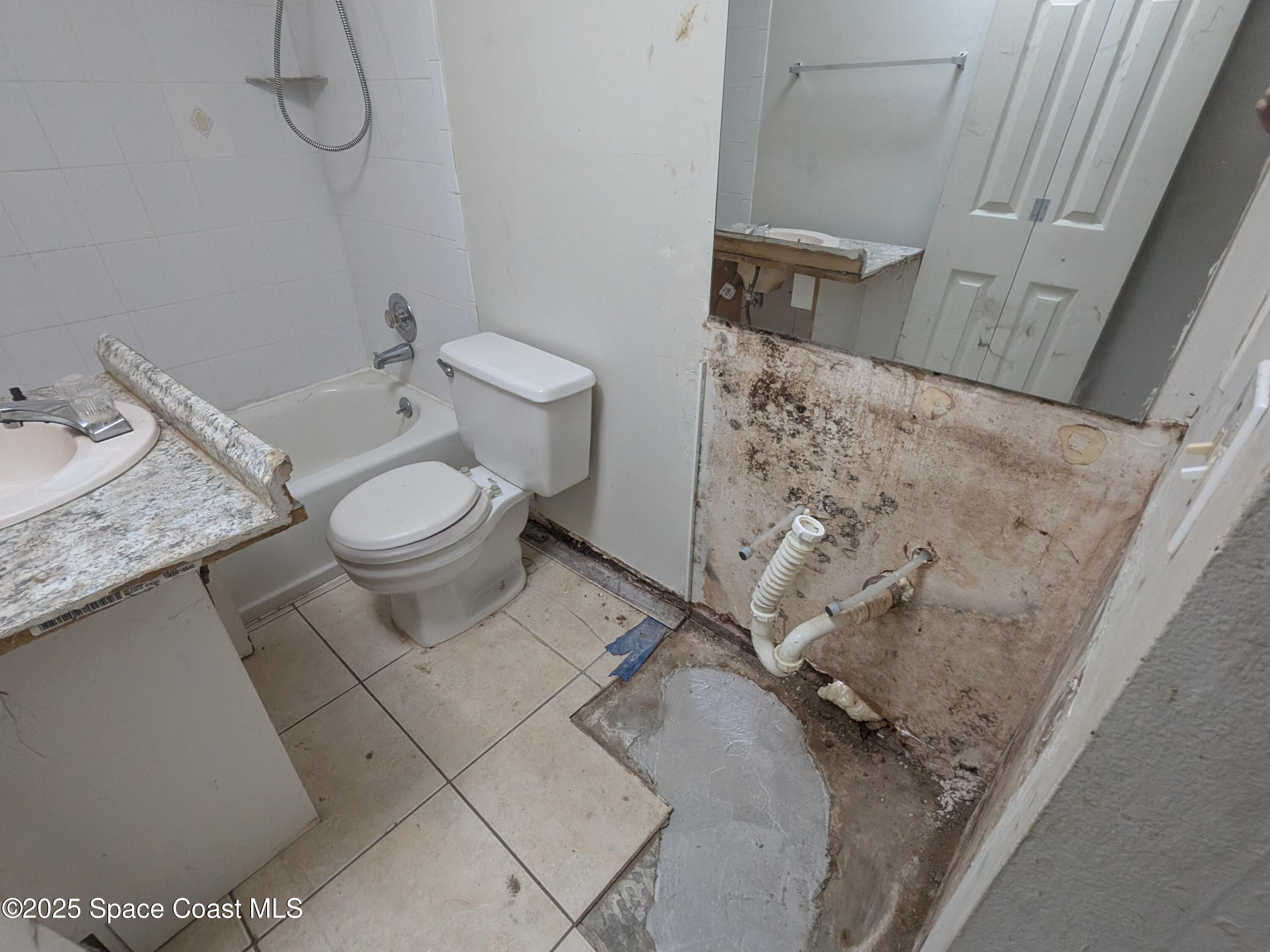 553 Rock Pit Road Titusville, FL 32796 - Photo 12 of 14 a bathroom with a granite countertop toilet and a sink