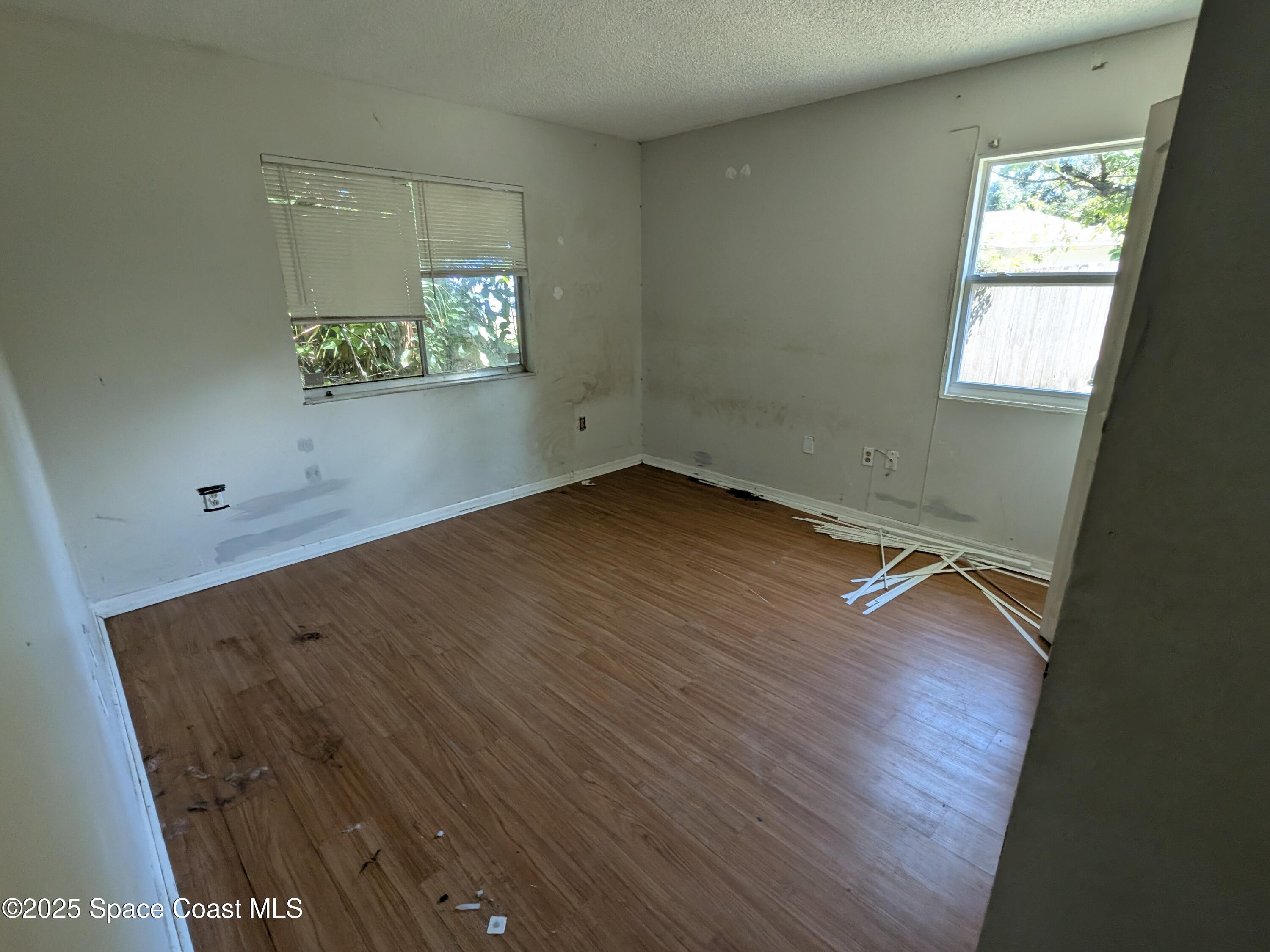 553 Rock Pit Road Titusville, FL 32796 - Photo 10 of 14 an empty room with wooden floor and windows