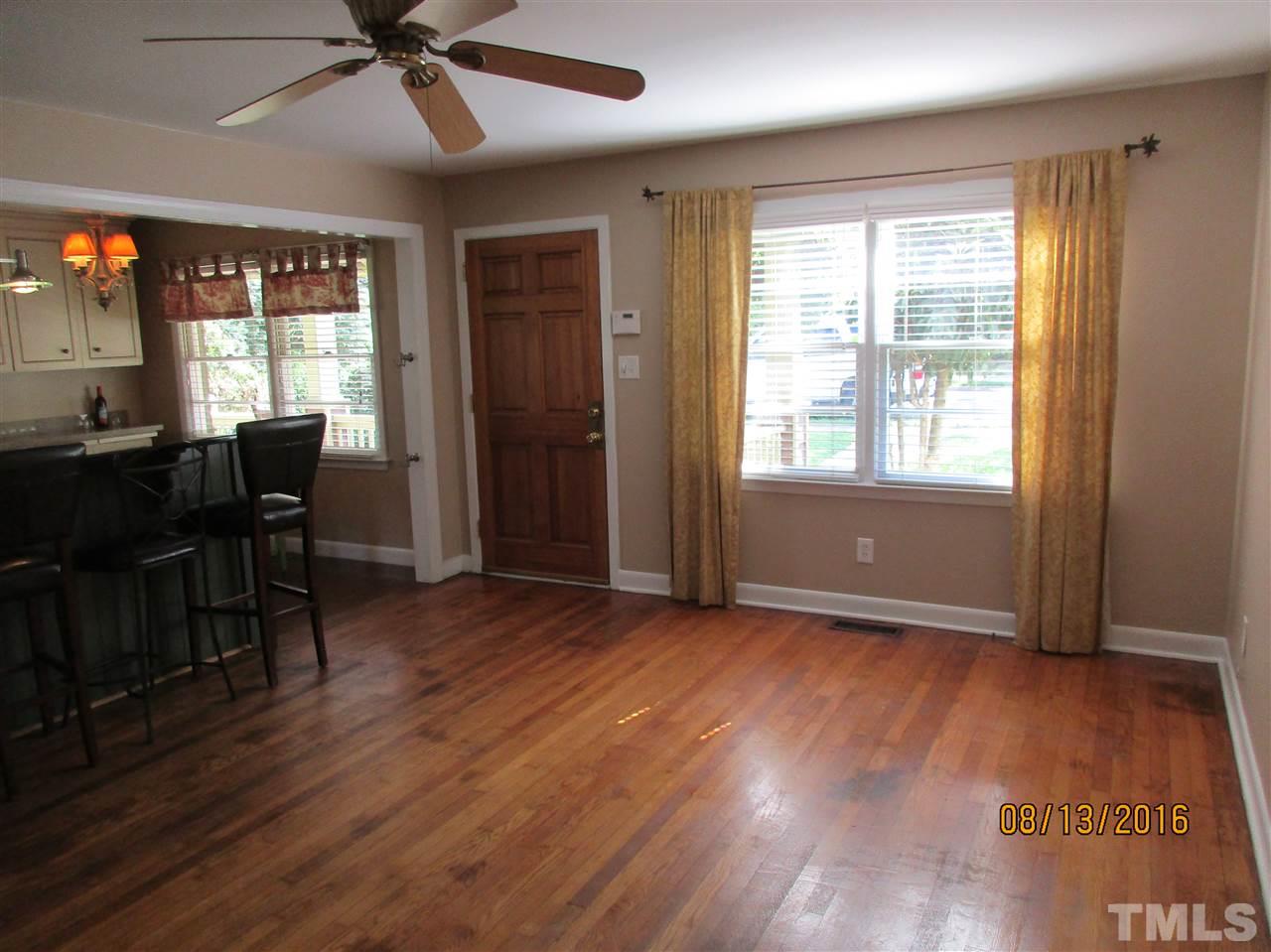 1642 Bickett Boulevard Raleigh, NC 27608 - Photo 5 of 25 an empty room with wooden floor fan and windows