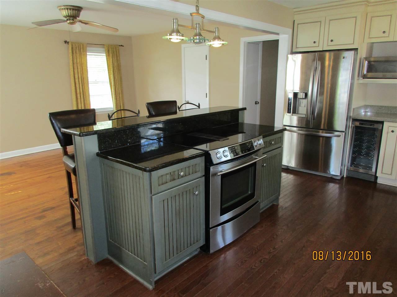 1642 Bickett Boulevard Raleigh, NC 27608 - Photo 8 of 25 a kitchen with granite countertop a stove and a refrigerator