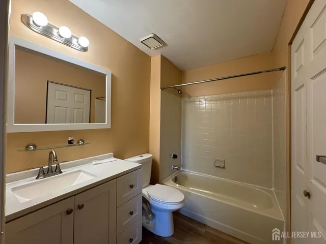 a bathroom with a double vanity sink toilet mirror and shower