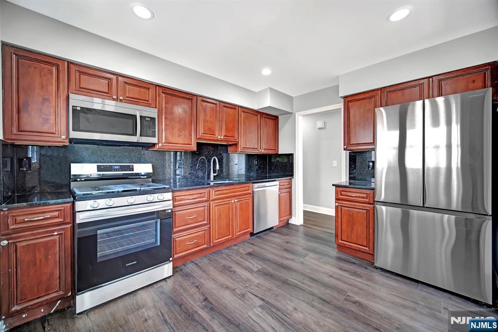 509 Grove Street Bloomfield, NJ 07017 - Photo 18 of 29 a kitchen with stainless steel appliances granite countertop a refrigerator microwave and stove top oven