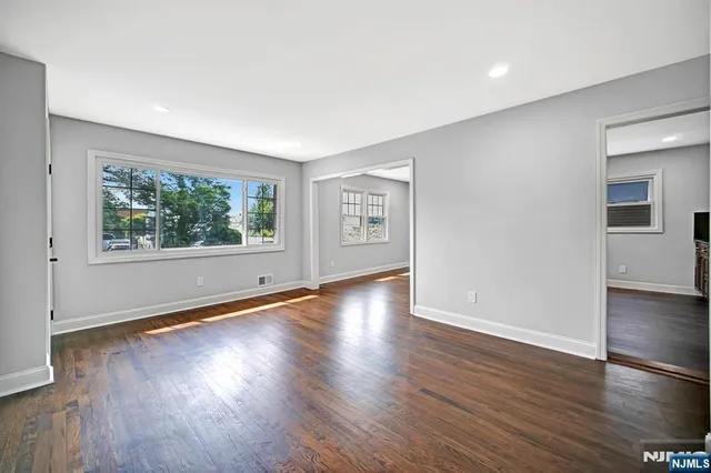 a view of a big room with wooden floor and a kitchen