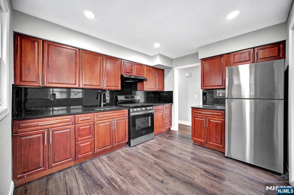 509 Grove Street Bloomfield, NJ 07017 - Photo 10 of 29 a kitchen with stainless steel appliances granite countertop a refrigerator a sink dishwasher a stove with wooden cabinets and wooden floor