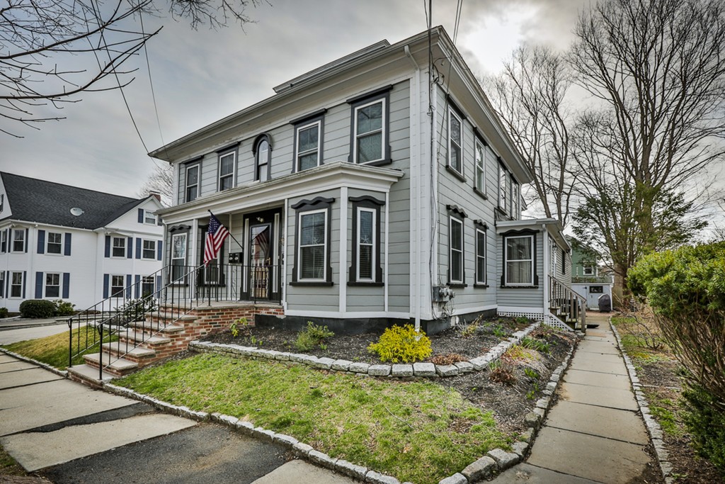 a front view of a house with swimming pool and couches chairs