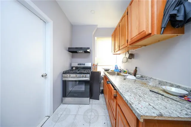 a kitchen with granite countertop a stove and a sink