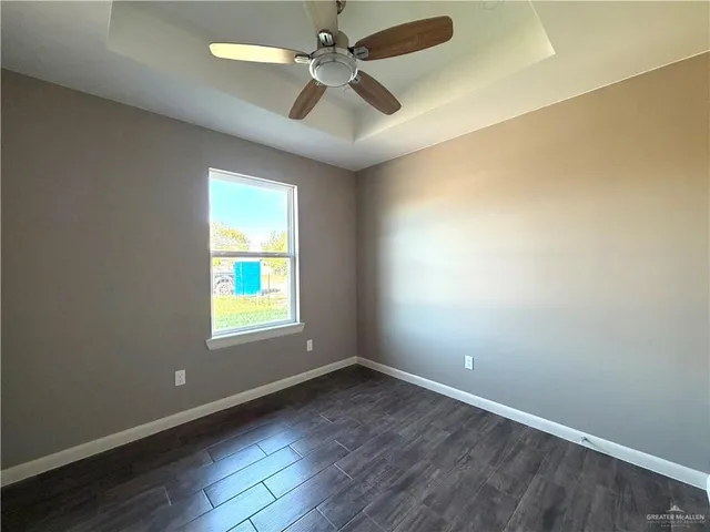 an empty room with a window and a fan