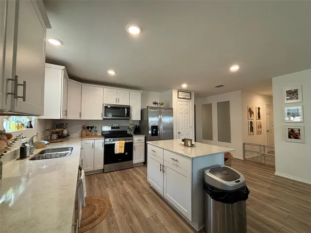 a kitchen with a sink stainless steel appliances and cabinets