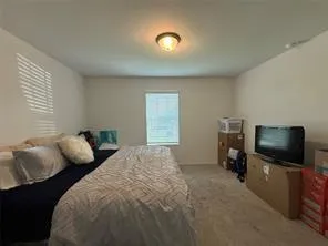 a bedroom with furniture and a flat screen tv
