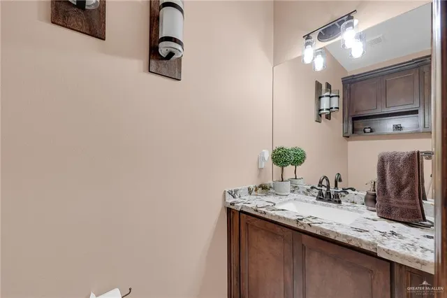 a bathroom with a granite countertop sink a large mirror and vanity