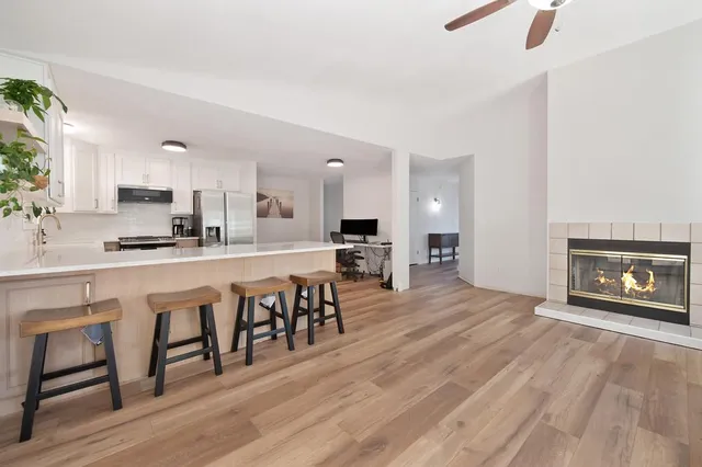 a large kitchen with kitchen island a dining table chairs and a wooden floor