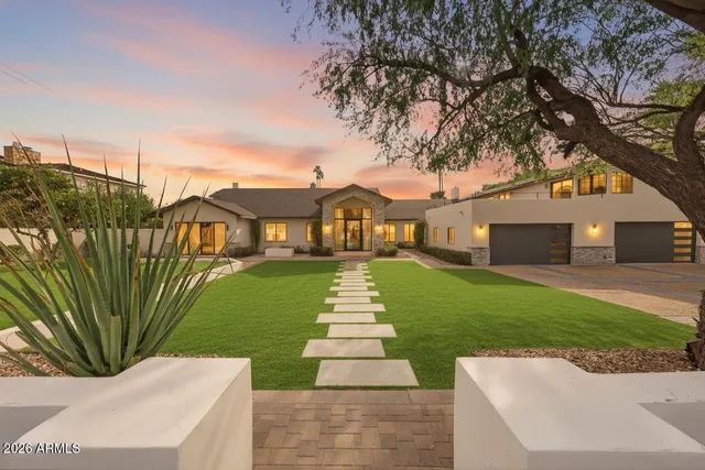 a front view of a house with a garden and fountain