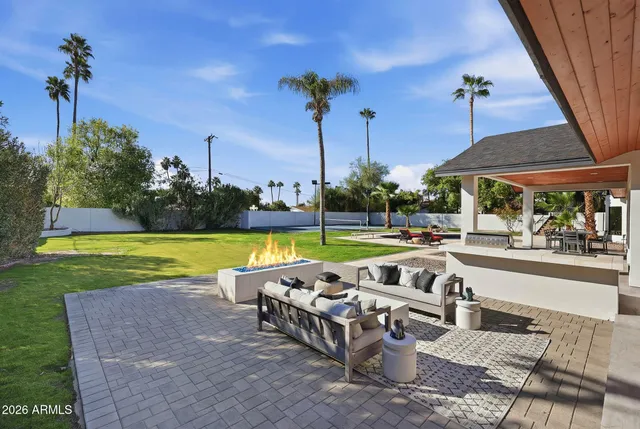 a view of a swimming pool with a yard and palm trees