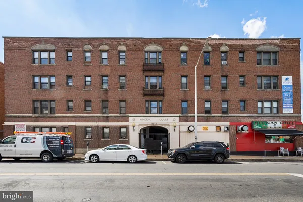 a view of building with cars parked in front of it