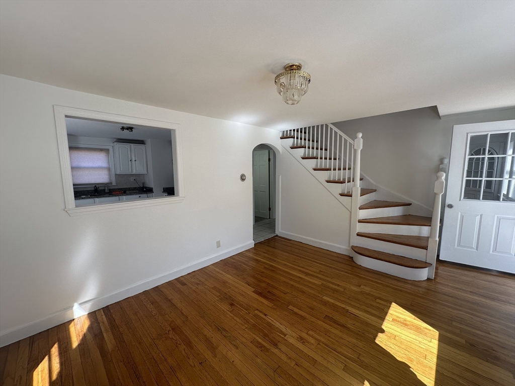 206 Adams Street, Unit 206 Newton, MA 02458 - Photo 11 of 37 a view of an empty room with wooden floor and stairs