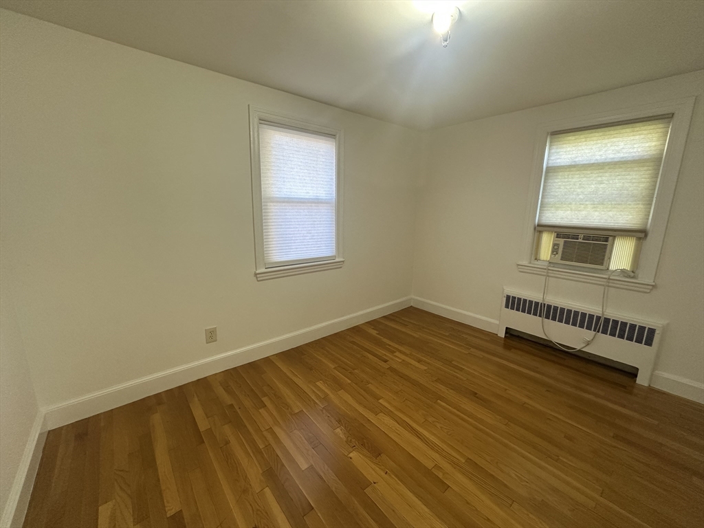 206 Adams Street, Unit 206 Newton, MA 02458 - Photo 13 of 37 a view of an empty room with wooden floor and a window