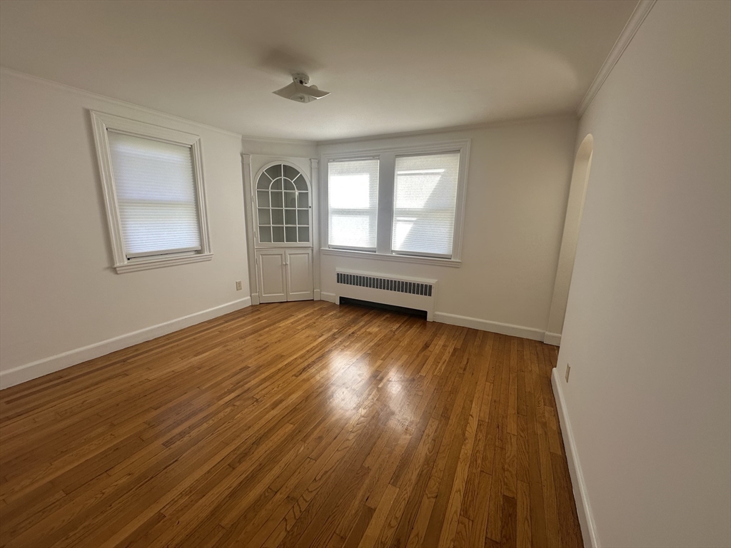 206 Adams Street, Unit 206 Newton, MA 02458 - Photo 15 of 37 a view of empty room with wooden floor and fan