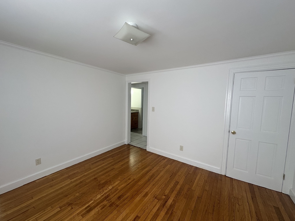 206 Adams Street, Unit 206 Newton, MA 02458 - Photo 16 of 37 a view of an empty room with wooden floor and a window