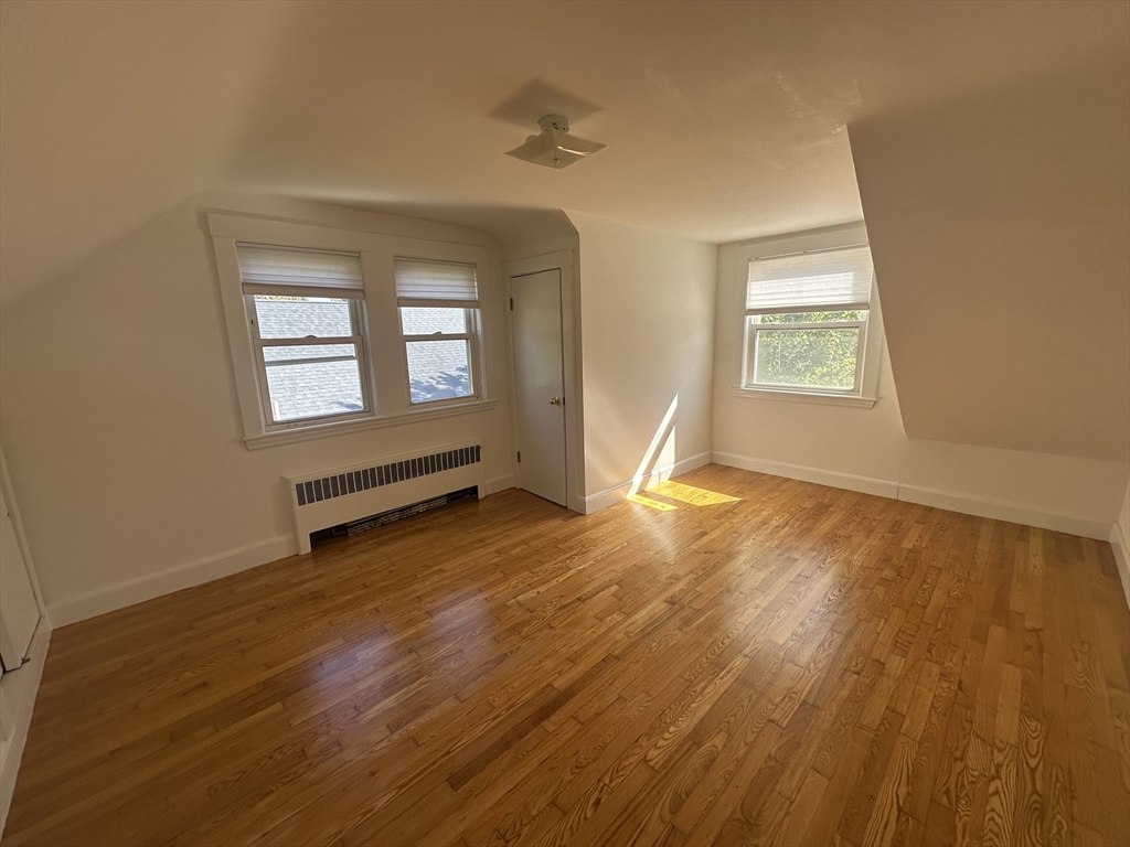 206 Adams Street, Unit 206 Newton, MA 02458 - Photo 19 of 37 a view of an empty room with wooden floor and a window